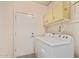 A laundry room featuring overhead storage and a white washer and dryer at 9644 N 97Th Ln, Peoria, AZ 85345
