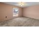 A carpeted bedroom with a ceiling fan and one window allowing in plenty of light at 9905 W Timberline Dr, Sun City, AZ 85351