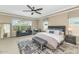 Serene main bedroom featuring plush bedding, ample natural light, and a ceiling fan at 10148 W Avenida Del Rey --, Peoria, AZ 85383