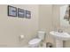 Neat half-bathroom featuring a pedestal sink, toilet, and simple decor, offering convenience for guests at 10148 W Avenida Del Rey --, Peoria, AZ 85383