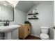 Charming half bathroom with a pedestal sink, floating shelves, and modern fixtures at 10451 E Natal Ave, Mesa, AZ 85209