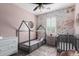 A charming bedroom features a canopy bed, a crib, and a decorative floral wallpaper at 10451 E Natal Ave, Mesa, AZ 85209