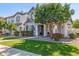 Inviting front exterior showcases a well-manicured lawn, mature tree, and a charming gray and white two-story home at 10451 E Natal Ave, Mesa, AZ 85209