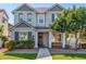 Charming two-story home featuring gray stucco, dark trim, a welcoming front porch, and manicured landscaping at 10451 E Natal Ave, Mesa, AZ 85209