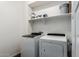 Functional laundry room with a washer, dryer, and shelving for storage at 10451 E Natal Ave, Mesa, AZ 85209