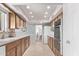 A well-lit kitchen features matching wood cabinets with tile flooring that leads to the dining area at 10516 W El Capitan Cir, Sun City, AZ 85351