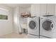 Functional laundry room features modern washer and dryer, storage cabinets, sink, and window for natural light at 10516 W El Capitan Cir, Sun City, AZ 85351