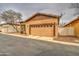 Garage with stucco exteriors, a bare tree, and a two-car garage is visible at 1155 S Annie Ln, Gilbert, AZ 85296