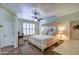 Comfortable main bedroom with a ceiling fan and bright windows with plantation shutters at 1155 S Annie Ln, Gilbert, AZ 85296