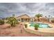 Backyard with a refreshing pool, covered patio, and lush desert landscaping at 12450 W Holly St, Avondale, AZ 85392