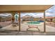 Backyard oasis with a pool, outdoor seating, and landscaping viewed from the covered patio at 12450 W Holly St, Avondale, AZ 85392