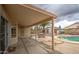 A covered patio seating area overlooks a pool, complemented by lush greenery, enhancing the outdoor experience at 12450 W Holly St, Avondale, AZ 85392