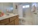 Bathroom with a single sink vanity, toilet, and tub with shower; bright and functional space at 12450 W Holly St, Avondale, AZ 85392