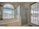 Bright bathroom with a frosted glass shower and a garden tub at 12450 W Holly St, Avondale, AZ 85392