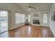 Cozy living room featuring a fireplace, wood floors, large windows, and ceiling fan at 12450 W Holly St, Avondale, AZ 85392