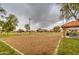 Outdoor volleyball court with sand surface, net, covered picnic tables, and well-kept green space for neighborhood recreation at 12450 W Holly St, Avondale, AZ 85392