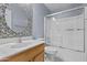 Well-lit bathroom featuring a modern sink, vanity, toilet, and glass-enclosed shower with colorful tiles at 12454 W Redfield Rd, El Mirage, AZ 85335