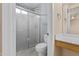 Well-lit bathroom featuring a modern sink, vanity, toilet, and shower with glass doors at 12454 W Redfield Rd, El Mirage, AZ 85335