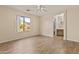 Bedroom has wood-look floors, neutral walls and ceiling fan, and a view to the exterior and ensuite at 12454 W Redfield Rd, El Mirage, AZ 85335