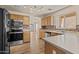 Spacious kitchen featuring stainless steel appliances, backsplash, wood cabinets and an island at 12454 W Redfield Rd, El Mirage, AZ 85335