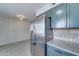 Bright kitchen featuring a stainless steel fridge, granite countertops, tiled backsplash, and light wood flooring at 1320 E Bethany Home Rd # 104, Phoenix, AZ 85014