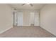 A generously-sized bedroom with neutral carpet, ceiling fan, and doorways to the bathroom and closet at 14024 N Palm Ridge Dr, Sun City, AZ 85351