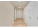 Hallway with neutral-toned walls, modern light-colored wood floors, and doors leading to various rooms at 14024 N Palm Ridge Dr, Sun City, AZ 85351