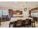 Bright kitchen with a large marble island, dark wood cabinetry, stainless steel appliances and breakfast bar at 14870 W Aldea Cir, Litchfield Park, AZ 85340