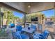 Spacious covered outdoor kitchen area with stainless steel appliances, grill, flat-screen TV, and cozy seating at 14870 W Aldea Cir, Litchfield Park, AZ 85340