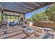 Covered outdoor kitchen and dining area featuring custom grill, sink, television and outdoor seating with a firepit at 14870 W Aldea Cir, Litchfield Park, AZ 85340