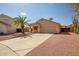 Charming single-story home featuring desert landscaping, a palm tree, and an attached two-car garage at 14932 W Lamoille Dr, Surprise, AZ 85374