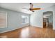 Bright, airy living room features gleaming hardwood floors, neutral paint, and a view into the kitchen at 14932 W Lamoille Dr, Surprise, AZ 85374