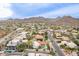 Expansive aerial view of the neighborhood with lush landscaping, mountain backdrop, and winding roads at 15327 E Thistle Dr, Fountain Hills, AZ 85268