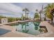 Tranquil pool with palm tree reflections, lush landscaping, and mountains in the background at 15327 E Thistle Dr, Fountain Hills, AZ 85268