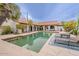 Inviting pool area with lounge chairs, tiled edges, lush greenery, and an American flag at 15327 E Thistle Dr, Fountain Hills, AZ 85268