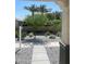 Inviting front yard featuring desert landscaping, including gravel, trees, and a view of palm trees in the distance at 15577 S 181St Ln, Goodyear, AZ 85338