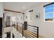 Bright hallway featuring modern black iron railings, beautiful trim, and abundant natural light from multiple windows at 15577 S 181St Ln, Goodyear, AZ 85338