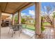 Charming back porch with an outdoor seating area, a manicured lawn, and lush greenery surrounding the backyard at 1562 W Lacewood Pl, Phoenix, AZ 85045