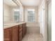 Bathroom featuring double sinks, modern fixtures, a large window, and a soaking tub at 1562 W Lacewood Pl, Phoenix, AZ 85045