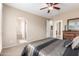 Cozy bedroom with plush carpet, a ceiling fan, and an arched doorway that leads to an ensuite bathroom at 1562 W Lacewood Pl, Phoenix, AZ 85045