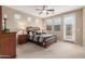 Inviting bedroom with a ceiling fan, plush carpet, and ample natural light from a glass door and windows at 1562 W Lacewood Pl, Phoenix, AZ 85045