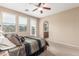 Bright bedroom with a ceiling fan, plush carpet, and plenty of natural light from a glass door and windows at 1562 W Lacewood Pl, Phoenix, AZ 85045