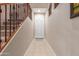 Inviting tiled entryway leading to a paneled white door and staircase with carpeted steps and dark wood banister at 1562 W Lacewood Pl, Phoenix, AZ 85045