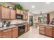 Traditional kitchen featuring tile floors, wooden cabinetry, and an adjacent dining area with abundant natural light at 1562 W Lacewood Pl, Phoenix, AZ 85045