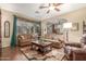 Cozy living room with comfortable seating, ceiling fan, and natural light from a large window at 1562 W Lacewood Pl, Phoenix, AZ 85045