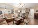 Open-concept living area flows into the dining area, featuring a ceiling fan and hardwood flooring at 1562 W Lacewood Pl, Phoenix, AZ 85045