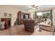 Inviting living room featuring wood floors, a ceiling fan, and an entertainment center with a built-in TV at 1562 W Lacewood Pl, Phoenix, AZ 85045