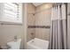 Well-lit bathroom featuring a tub with tiled walls and a shower curtain at 16935 W Cambridge Ave, Goodyear, AZ 85395