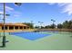 Outdoor tennis court featuring a blue court surface and a green surrounding area for recreational play at 16935 W Cambridge Ave # 57, Goodyear, AZ 85395