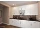 Close-up of the wine bar, featuring white cabinets, a wine rack, and mosaic backsplash at 16935 W Cambridge Ave # 57, Goodyear, AZ 85395